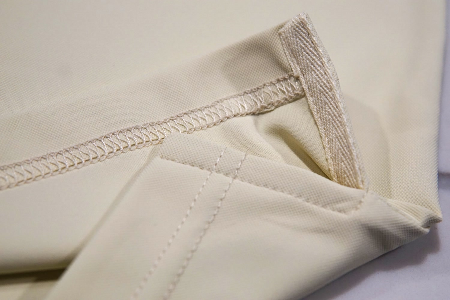 Double-stitched hem and reinforced side vent of the polo